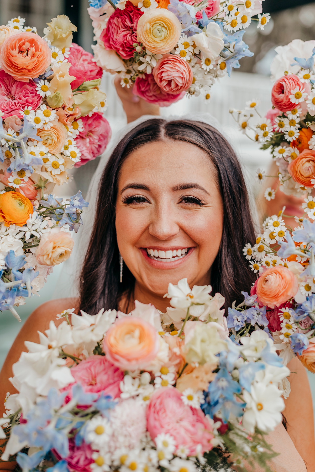 Photo of bride with colorful bouquets around her